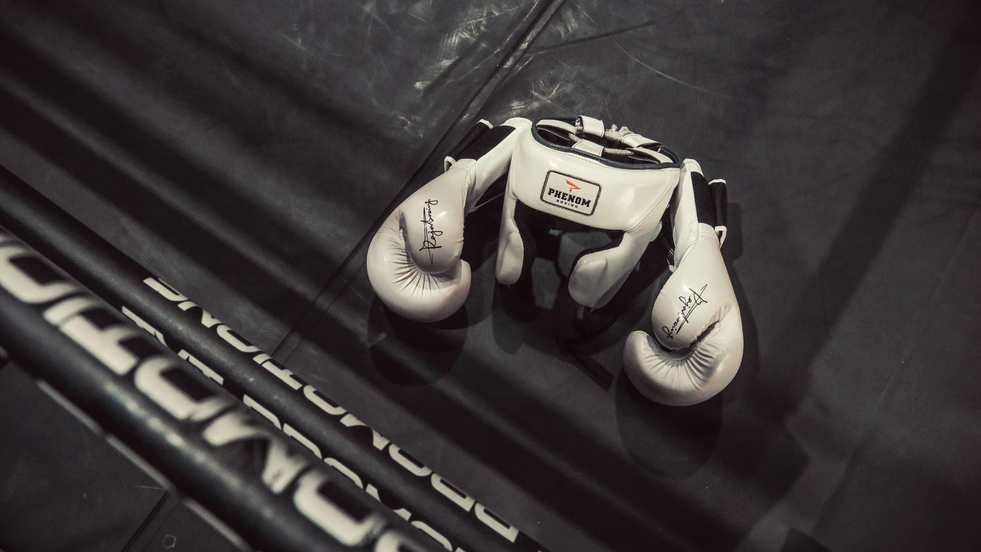 White boxing gloves and headgear on a ring floor